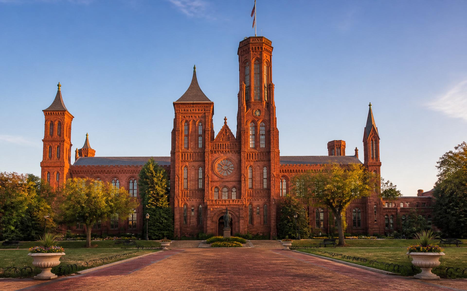The College's main building — a red sandstone hall with prominent towers, rendered in the tradition of the Smithsonian Castle.